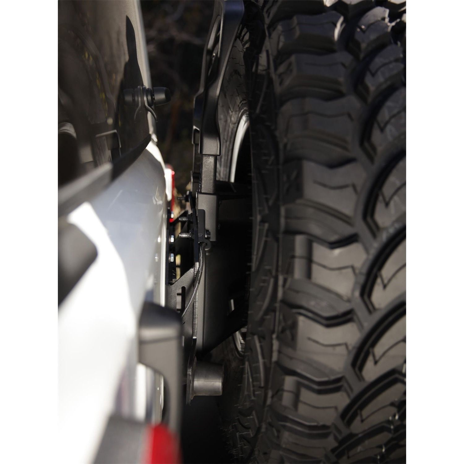 SMITTYBILT | JL Tire Relocation Bracket 2018-Up Jeep Wrangler JL Smittybilt |7721 mounted on a Jeep with a 37-inch tire.