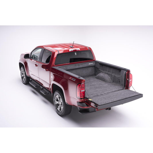 BedRug 23-25 Colorado/Canyon Crew Cab 5' Bed Liner w/ Tailgate Mat - Charcoal (BRB23CCK) installed in a red truck bed.