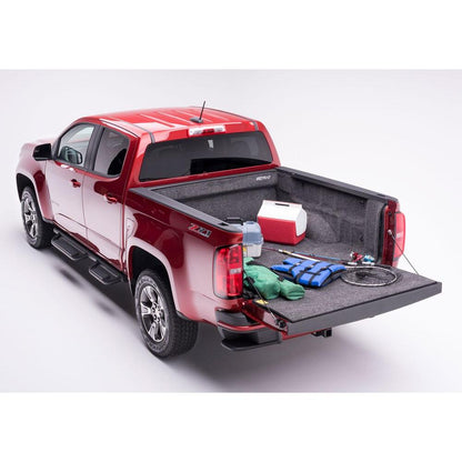 BedRug 23-25 Colorado/Canyon Crew Cab 5' Bed Liner w/ Tailgate Mat - Charcoal (BRB23CCK) installed in a red truck bed.