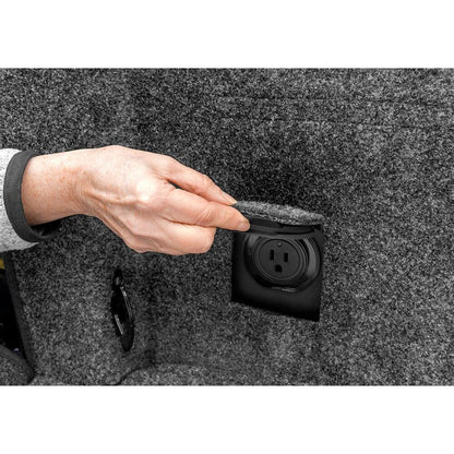Hand removing cover from power outlet in BedRug 2015-2025 Ford F-150 6'7" Bed Liner w/ Tailgate Mat - Charcoal (BRQ15SBK)