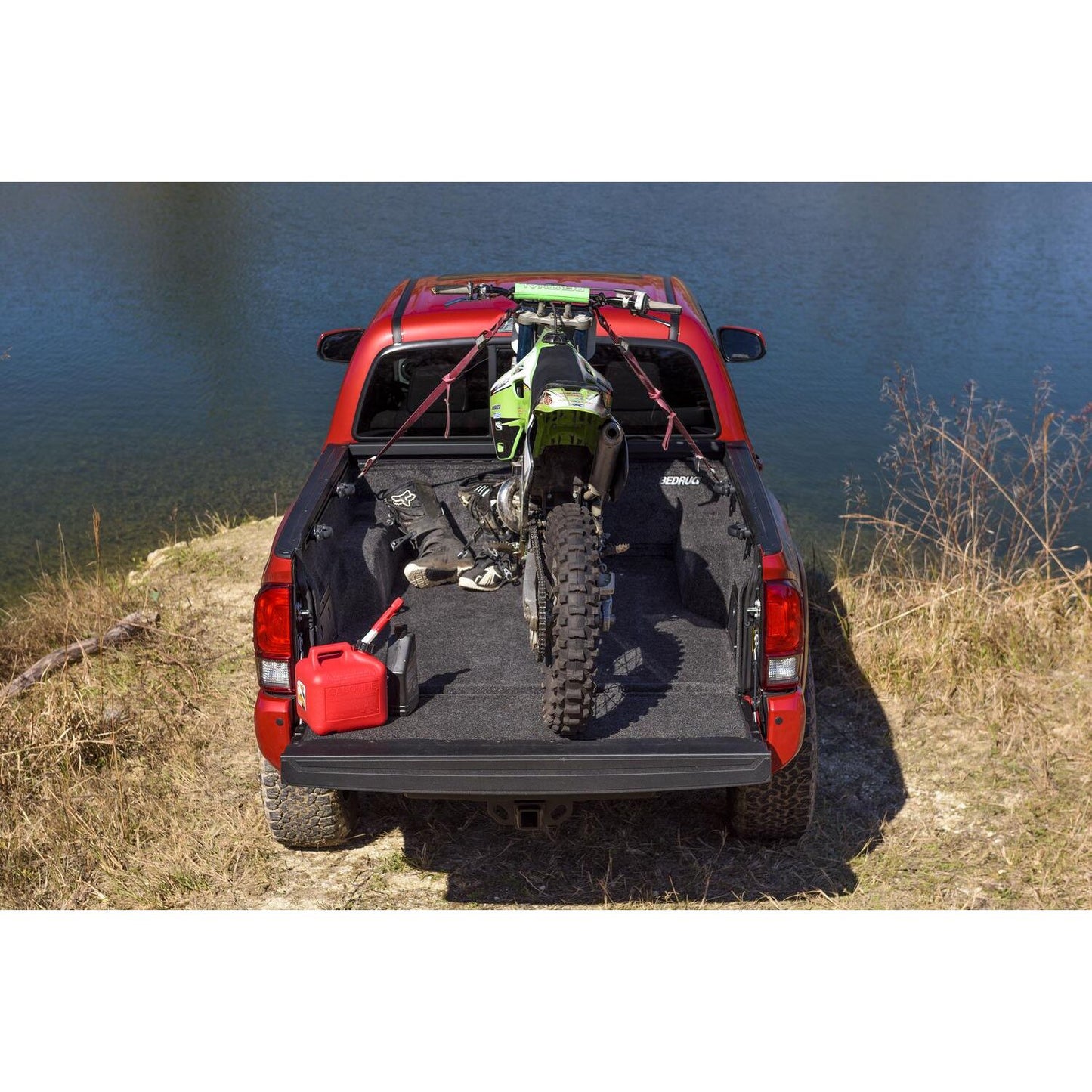 BedRug 05+ Toyota Tacoma 5' Bed Liner w/ Tailgate Mat - Charcoal (BRY19DCK) with motorcycle in truck bed by water.