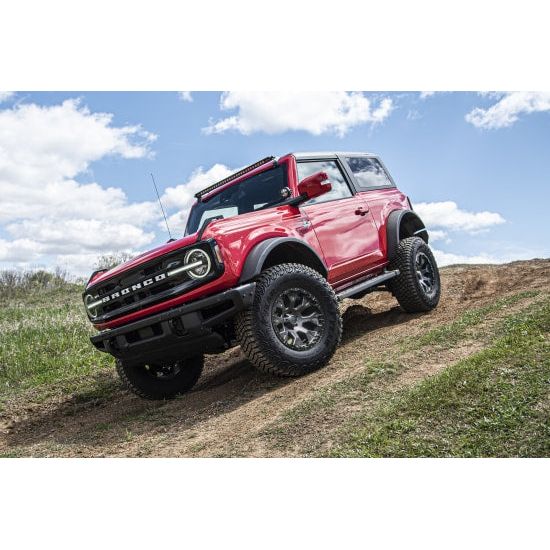 ZONE OFFROAD |  1 Inch Leveling Kit   I ZONF1102 installed on a red Ford Bronco navigating off-road terrain.